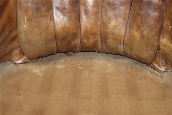 A George III mahogany hide-covered wing chair